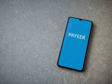 Lod, Israel - 16 Temmuz 2023: PaYEER uygulaması seramik taş zemin üzerinde akıllı telefon fırlatma ekranı. Üst görünüm düzlüğü kopyalama alanı ile yatıyordu.