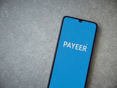 Lod, Israel - 16 Temmuz 2023: PaYEER uygulaması seramik taş zemin üzerinde akıllı telefon fırlatma ekranı. Üst görünüm düzlüğü kopyalama alanı ile yatıyordu.