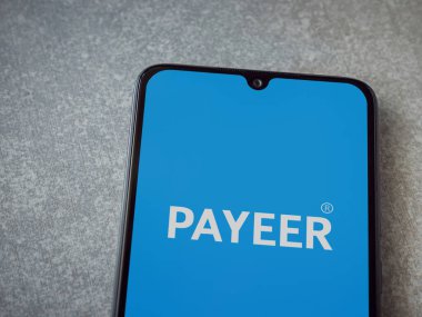Lod, Israel - 16 Temmuz 2023: PaYEER uygulaması seramik taş zemin üzerinde akıllı telefon fırlatma ekranı. Üst görünüm düzlüğü kopyalama alanı ile yatıyordu.