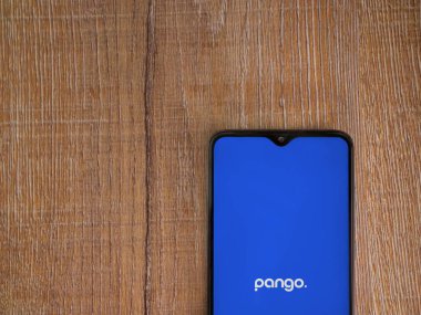 Lod, Israel - 16 Temmuz 2023: Pango uygulaması ahşap arka planda akıllı telefondan çalıştırma ekranı. Üst görünüm düzlüğü kopyalama alanı ile yatıyordu.