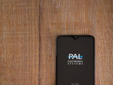 Lod, Israel - 16 Temmuz 2023: Palgate uygulama ekranı ahşap arka planda akıllı telefon. Üst görünüm düzlüğü kopyalama alanı ile yatıyordu.