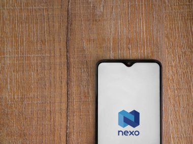 Lod, Israel - 16 Temmuz 2023: Ahşap arka planda akıllı telefondan Nexo uygulama fırlatma ekranı. Üst görünüm düzlüğü kopyalama alanı ile yatıyordu.