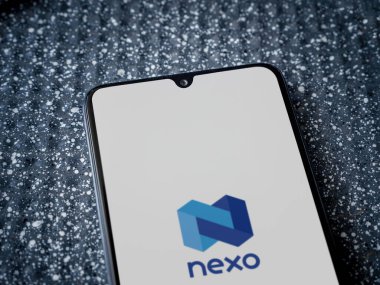 Lod, Israel - 16 Temmuz 2023: Metalik arkaplanda akıllı telefondan Nexo uygulaması fırlatma ekranı. Üst görünüm yatağını kapat.