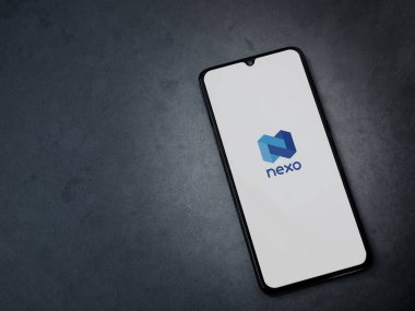 Lod, Israel - 16 Temmuz 2023: Koyu mermer taşlı arka planda akıllı telefondan Nexo uygulaması fırlatma ekranı. Üst görünüm düzlüğü kopyalama alanı ile yatıyordu.
