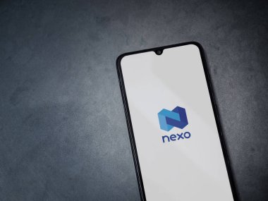 Lod, Israel - 16 Temmuz 2023: Koyu mermer taşlı arka planda akıllı telefondan Nexo uygulaması fırlatma ekranı. Üst görünüm düzlüğü kopyalama alanı ile yatıyordu.