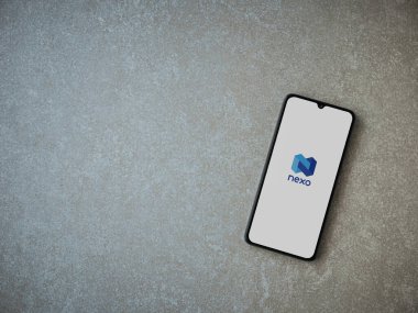 Lod, Israel - 16 Temmuz 2023: Seramik taş zemin üzerinde akıllı telefondan Nexo uygulaması fırlatma ekranı. Üst görünüm düzlüğü kopyalama alanı ile yatıyordu.
