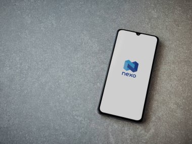Lod, Israel - 16 Temmuz 2023: Seramik taş zemin üzerinde akıllı telefondan Nexo uygulaması fırlatma ekranı. Üst görünüm düzlüğü kopyalama alanı ile yatıyordu.