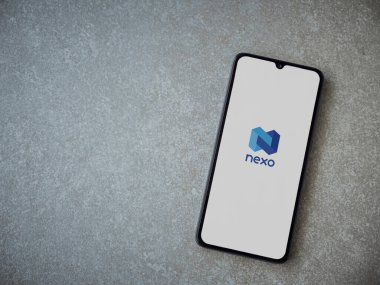 Lod, Israel - 16 Temmuz 2023: Seramik taş zemin üzerinde akıllı telefondan Nexo uygulaması fırlatma ekranı. Üst görünüm düzlüğü kopyalama alanı ile yatıyordu.