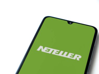 Lod, Israel - 16 Temmuz 2023: NETELLER uygulaması beyaz arkaplanda akıllı telefondan çalıştırma ekranı. Üst görünüm düzlüğü kopyalama alanı ile yatıyordu.