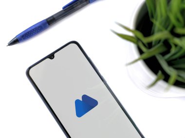 Lod, Israel - 16 Temmuz 2023: Beyaz arka planda MEXC uygulamalı akıllı telefonlu modern çalışma alanı. Üst görünüm yatağını kapat.