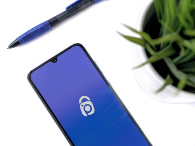 Lod, Israel - 16 Temmuz 2023: IDrive Fotoğraf Yedekleme uygulaması olan modern çalışma alanı beyaz arka planda. Üst görünüm yatağını kapat.