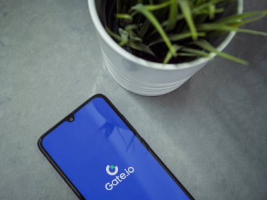 Lod, Israel - 16 Temmuz 2023: Mermer zemin üzerinde Gate.io uygulaması olan modern çalışma alanı. Üst görünüm yatağını kapat.