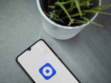 Lod, Israel - 16 Temmuz 2023: Mermer zemin üzerinde Coinbase Cüzdan uygulaması fırlatma ekranlı akıllı telefonlu modern çalışma alanı. Üst görünüm yatağını kapat.
