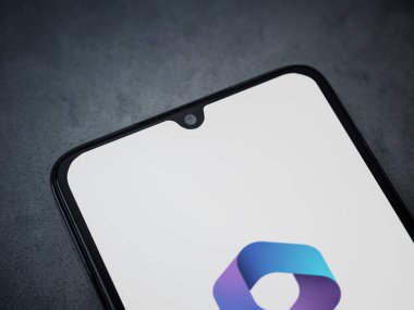Lod, Israel - 16 Temmuz 2023: Microsoft 360 uygulaması koyu mermer taşlı arka planda akıllı telefondan kalkış ekranı. Üst görünüm düzlüğü kopyalama alanı ile yatıyordu.