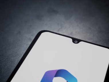 Lod, Israel - 16 Temmuz 2023: Microsoft 360 uygulaması koyu mermer taşlı arka planda akıllı telefondan kalkış ekranı. Üst görünüm düzlüğü kopyalama alanı ile yatıyordu.