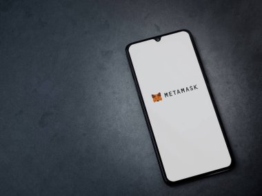 Lod, Israel - 16 Temmuz 2023: MetaMaske uygulaması koyu mermer taşlı arka planda akıllı telefondan kalkış ekranı. Üst görünüm düzlüğü kopyalama alanı ile yatıyordu.
