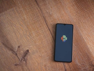 Lod, Israel - 16 Temmuz 2023: Makrodroid uygulama ekranı ahşap arka planda akıllı telefondan çalıştırıldı. Üst görünüm düzlüğü kopyalama alanı ile yatıyordu.