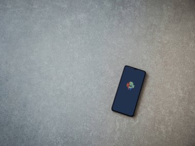 Lod, Israel - 16 Temmuz 2023: Makrodroid uygulaması seramik taş zemin üzerinde akıllı telefondan kalkış ekranı. Üst görünüm düzlüğü kopyalama alanı ile yatıyordu.