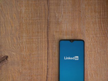 Lod, Israel - 16 Temmuz 2023: Ahşap arka planda akıllı telefondan uygulama başlatma ekranı. Üst görünüm düzlüğü kopyalama alanı ile yatıyordu.