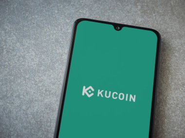 Lod, Israel - 16 Temmuz 2023: KuCoin uygulaması seramik taş zemin üzerinde akıllı telefondan fırlatma ekranı. Üst görünüm düzlüğü kopyalama alanı ile yatıyordu.