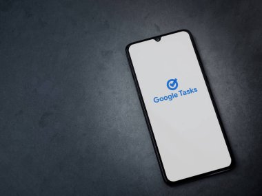 Lod, Israel - 16 Temmuz 2023: Google Görev uygulaması koyu mermer taşlı arka planda akıllı telefondan çalıştırma ekranı. Üst görünüm düzlüğü kopyalama alanı ile yatıyordu.