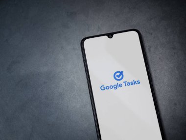 Lod, Israel - 16 Temmuz 2023: Google Görev uygulaması koyu mermer taşlı arka planda akıllı telefondan çalıştırma ekranı. Üst görünüm düzlüğü kopyalama alanı ile yatıyordu.