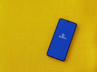 Lod, Israel - 16 Temmuz 2023: Sarı kumaş arka planda akıllı telefondan Gate.io uygulamasını çalıştırma ekranı. Üst görünüm düzlüğü kopyalama alanı ile yatıyordu.