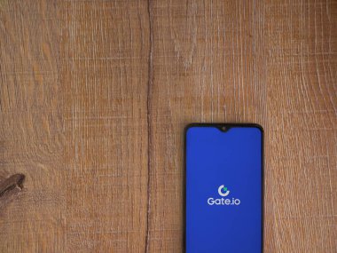 Lod, Israel - 16 Temmuz 2023: Ahşap zemin üzerinde akıllı telefondan Gate.io uygulaması fırlatma ekranı. Üst görünüm düzlüğü kopyalama alanı ile yatıyordu.