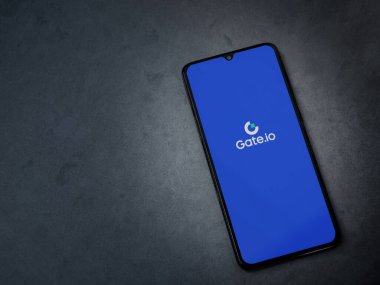 Lod, Israel - 16 Temmuz 2023: Koyu mermer taşlı arka planda akıllı telefondan Gate.io uygulaması fırlatma ekranı. Üst görünüm düzlüğü kopyalama alanı ile yatıyordu.
