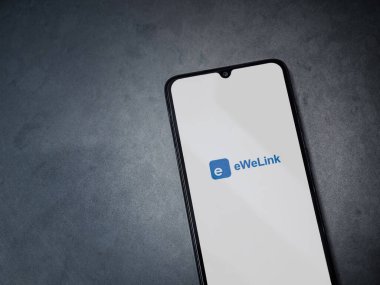 Lod, Israel - 16 Temmuz 2023: eWeLink uygulaması koyu mermer taşlı arka planda akıllı telefondan kalkış ekranı. Üst görünüm düzlüğü kopyalama alanı ile yatıyordu.