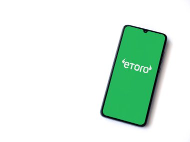 Lod, Israel - 16 Temmuz 2023: eToro uygulaması beyaz arka planda akıllı telefondan çalıştırma ekranı. Üst görünüm düzlüğü kopyalama alanı ile yatıyordu.