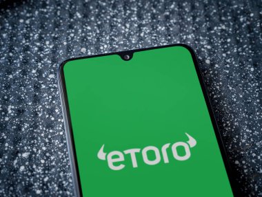 Lod, Israel - 16 Temmuz 2023: eToro uygulama ekranı metalik arka planda akıllı telefon. Üst görünüm yatağını kapat.