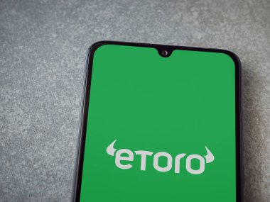 Lod, Israel - 16 Temmuz 2023: eToro uygulaması seramik taş zemin üzerinde akıllı telefondan çalıştırma ekranı. Üst görünüm düzlüğü kopyalama alanı ile yatıyordu.