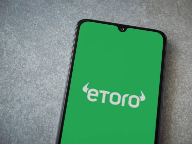 Lod, Israel - 16 Temmuz 2023: eToro uygulaması seramik taş zemin üzerinde akıllı telefondan çalıştırma ekranı. Üst görünüm düzlüğü kopyalama alanı ile yatıyordu.