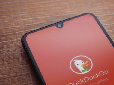 Lod, Israel - 16 Temmuz 2023: DuckDuckGo Özel Tarayıcı uygulama ekranı ahşap arka planda akıllı telefon. Üst görünüm düzlüğü kopyalama alanı ile yatıyordu.