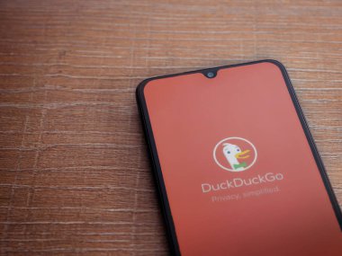 Lod, Israel - 16 Temmuz 2023: DuckDuckGo Özel Tarayıcı uygulama ekranı ahşap arka planda akıllı telefon. Üst görünüm düzlüğü kopyalama alanı ile yatıyordu.