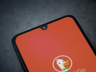 Lod, Israel - 16 Temmuz 2023: DuckDuckGo Özel Tarayıcı uygulaması koyu mermer taştan arka planda akıllı telefon ekranını çalıştırıyor. Üst görünüm düzlüğü kopyalama alanı ile yatıyordu.