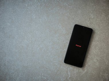 Lod, Israel - 16 Temmuz 2023: Seramik taş zemin üzerinde akıllı telefondan Depop uygulaması fırlatma ekranı. Üst görünüm düzlüğü kopyalama alanı ile yatıyordu.