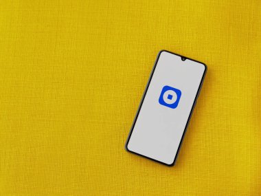 Lod, Israel - 16 Temmuz 2023: Cüzdan tabanı uygulaması sarı kumaş zemin üzerinde akıllı telefon fırlatma ekranı. Üst görünüm düzlüğü kopyalama alanı ile yatıyordu.