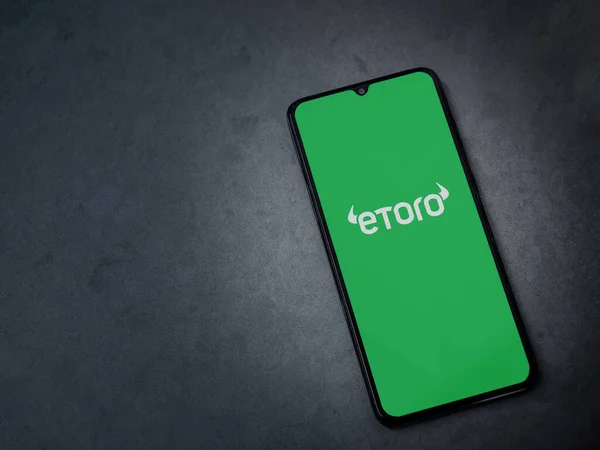 stock image Lod, Israel - July 16,2023: eToro app launch screen on smartphone on dark marble stone background. Top view flat lay with copy space.