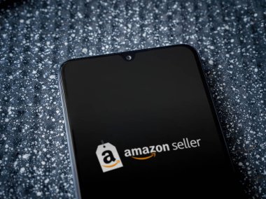 Lod, Israel - 16 Temmuz 2023: Amazon Seller uygulama ekranı metalik arka planda akıllı telefondan çalıştırıldı. Üst görünüm yatağını kapat.