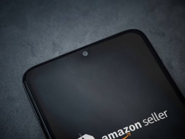 Lod, Israel - 16 Temmuz 2023: Amazon Seller uygulaması koyu mermer taşlı arka planda akıllı telefondan kalkış ekranı. Üst görünüm düzlüğü kopyalama alanı ile yatıyordu.
