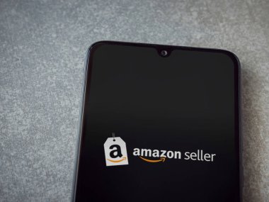 Lod, Israel - 16 Temmuz 2023: Amazon Seller uygulama ekranı seramik taş zemin üzerinde akıllı telefondan çalıştırılıyor. Üst görünüm düzlüğü kopyalama alanı ile yatıyordu.