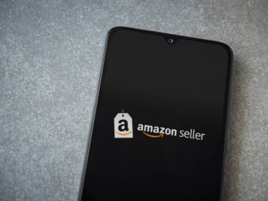 Lod, Israel - 16 Temmuz 2023: Amazon Seller uygulama ekranı seramik taş zemin üzerinde akıllı telefondan çalıştırılıyor. Üst görünüm düzlüğü kopyalama alanı ile yatıyordu.