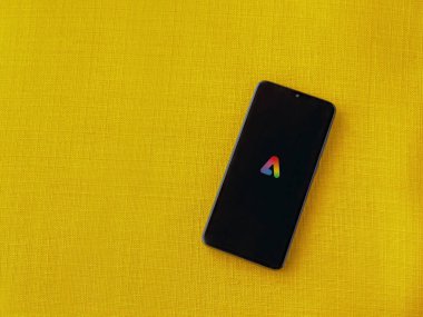 Lod, Israel - 16 Temmuz 2023: Adobe Express - Sarı kumaş arka planda akıllı telefon üzerinde grafiksel tasarım uygulama başlatma ekranı..