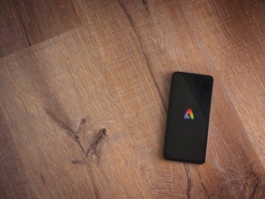 Lod, Israel - 16 Temmuz 2023: Adobe Express - Ahşap arkaplanda akıllı telefondan grafiksel tasarım uygulama başlatma ekranı. Üst görünüm düzlüğü kopyalama alanı ile yatıyordu.