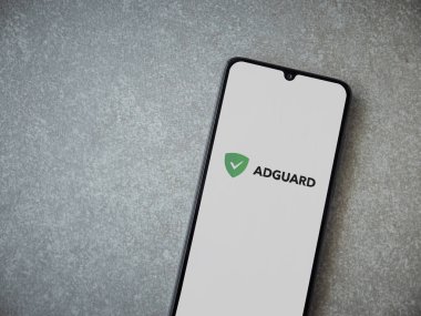 Lod, Israel - 16 Temmuz 2023: AdGuard uygulaması seramik taş zemin üzerinde akıllı telefondan çalıştırma ekranı. Üst görünüm düzlüğü kopyalama alanı ile yatıyordu.