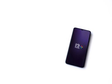 Lod, Israel - 16 Temmuz 2023: 12 + uygulama ekranı beyaz arkaplanda akıllı telefondan çalıştırılıyor. Üst görünüm düzlüğü kopyalama alanı ile yatıyordu.