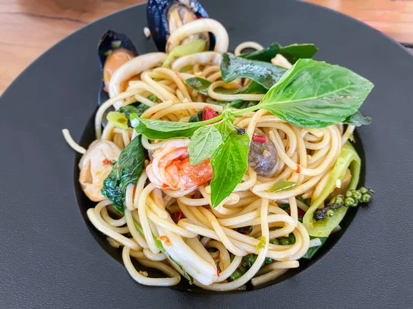 stock image Drunken seafood spaghetti in a black plate.