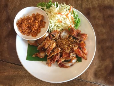 Beyaz bir tabakta muz yaprağında kızarmış domuz eti..